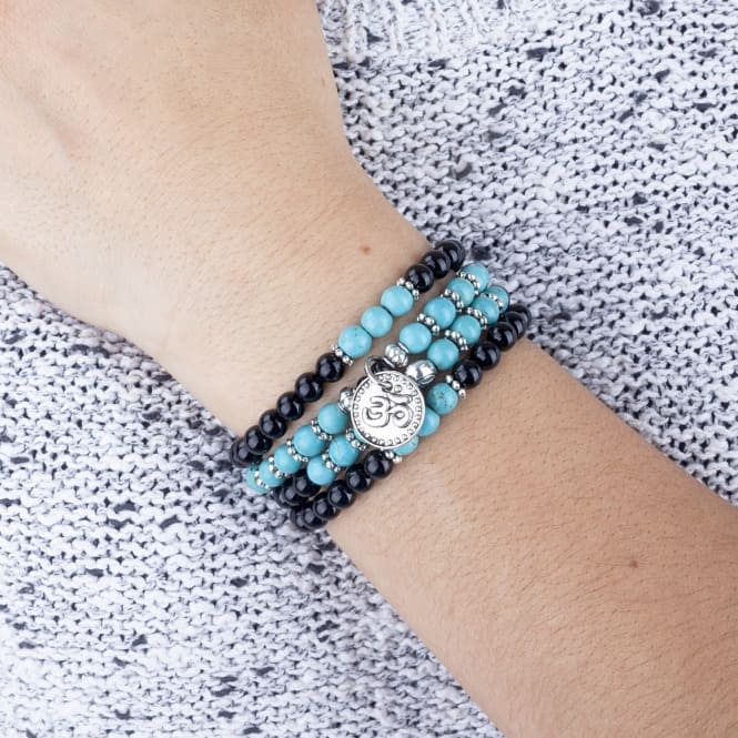 Bracciale collana elasticizzato in agata nera e turchese con simbolo 'OM', indossato al polso