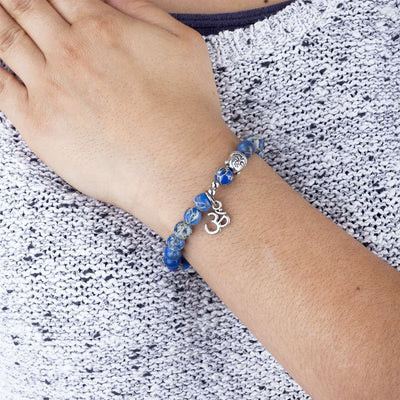 Braccialetto elasticizzato di perline di diaspro blu con charme (pendente) simbolo 'OM' indossato