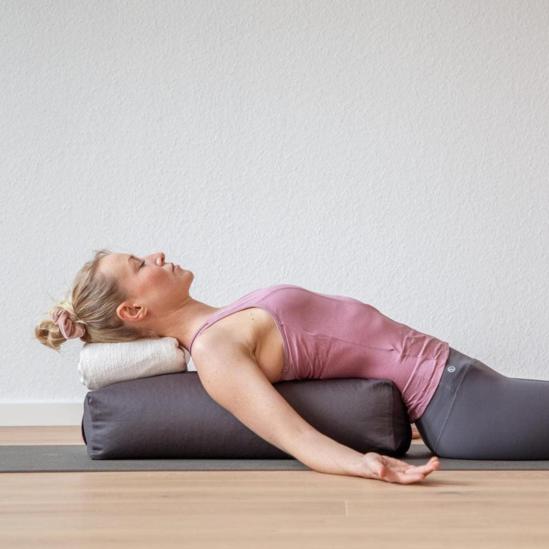 Bolster yoga grande rettangolare sfoderabile modella in posizione rilassata
