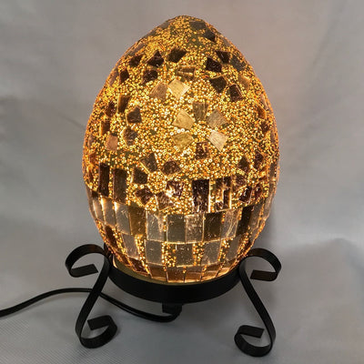 Lampada Mosaico toni dorati a forma d'uovo accesa