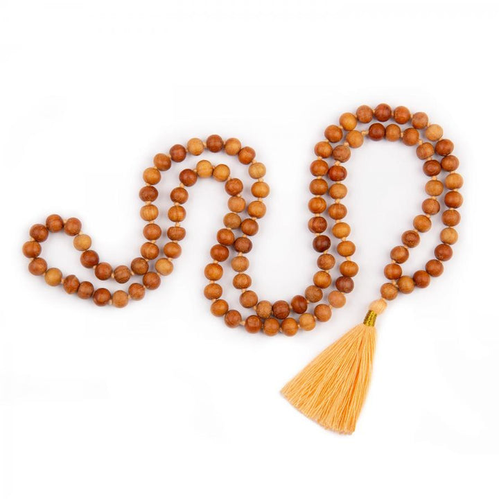 Mala in grani di legno di sandalo profumato, annodati singolarmente ad ogni grano, con nappina di colore pesca, 