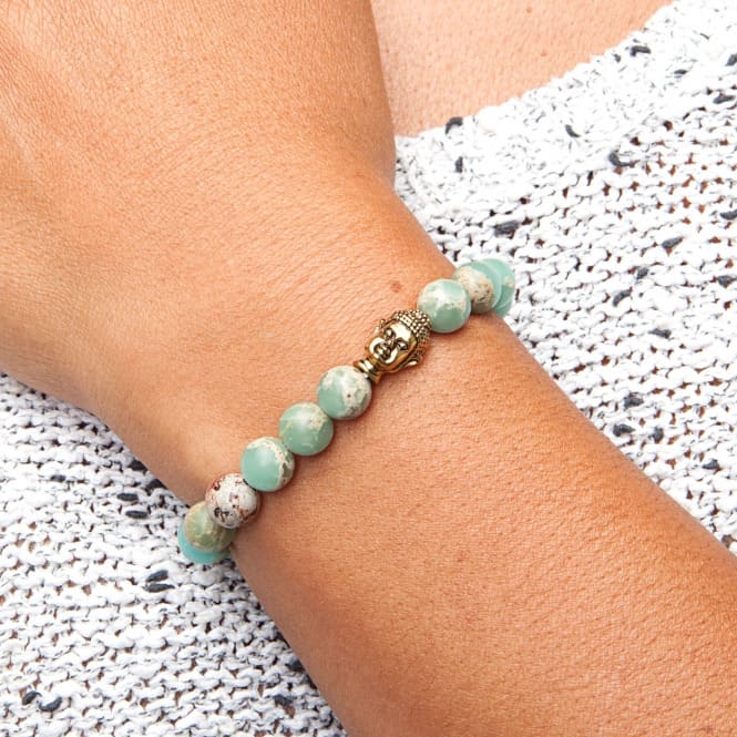 Bracciale elasticizzto in serpentina verde con testa di Buddha dorato indossato